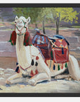 Painting of a decorated camel lying down with a colorful saddle on a stone surface.