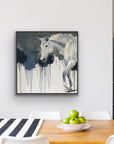 A white wall with a painting of a white horse walking and dripping dark background.