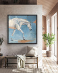 a white horse with a blue background and gold details, framed in a black, wooden frame.
