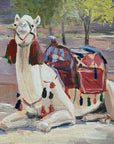 Painting of a white camel with a colorful saddle in a desert landscape