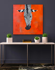 Zebra painting on an orange background above a table with decorative items.