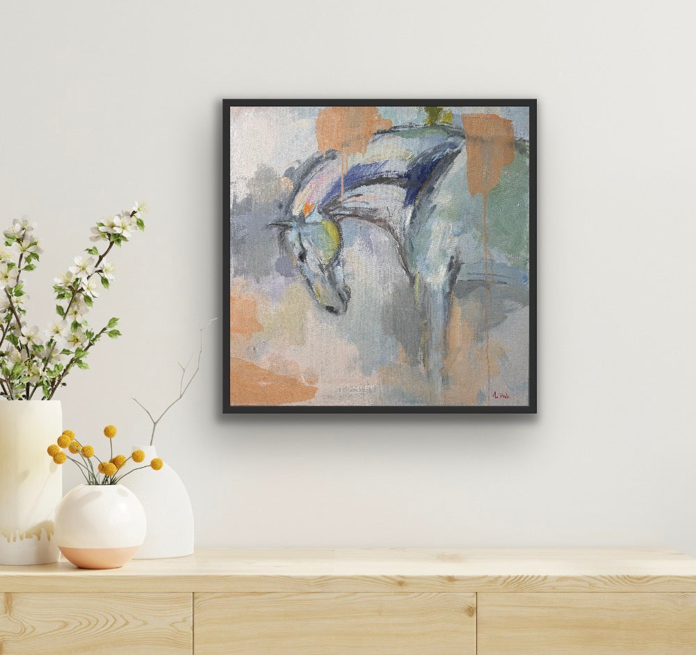 Framed abstract painting of a horse on a wall above a wooden shelf with decorative items.