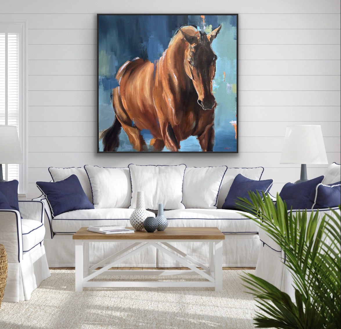 Living room with a horse painting on the wall above a sofa.